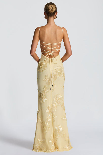 Back view of cream maxi dress with lace-up strappy back and gold embroidery