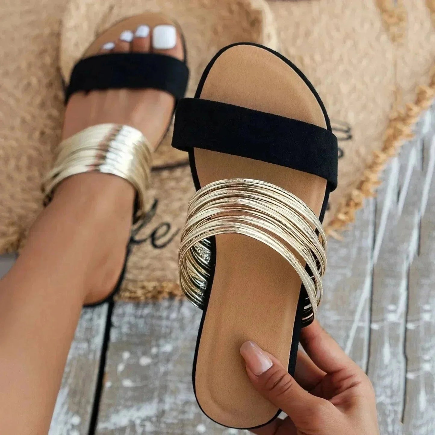 Black padded slide sandal with metallic gold straps and cushioned footbed
