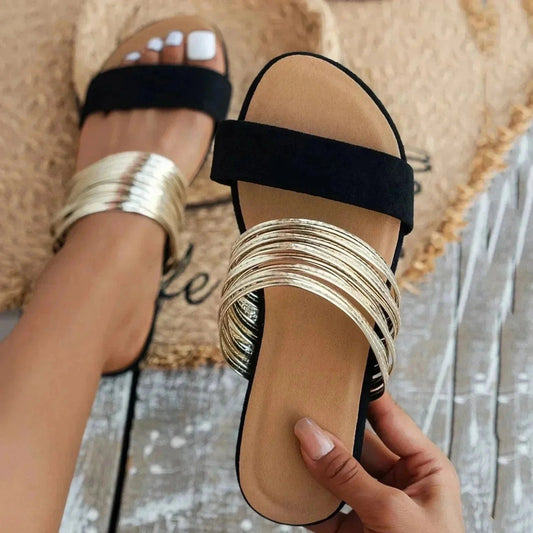 Black padded slide sandal with metallic gold straps and cushioned footbed