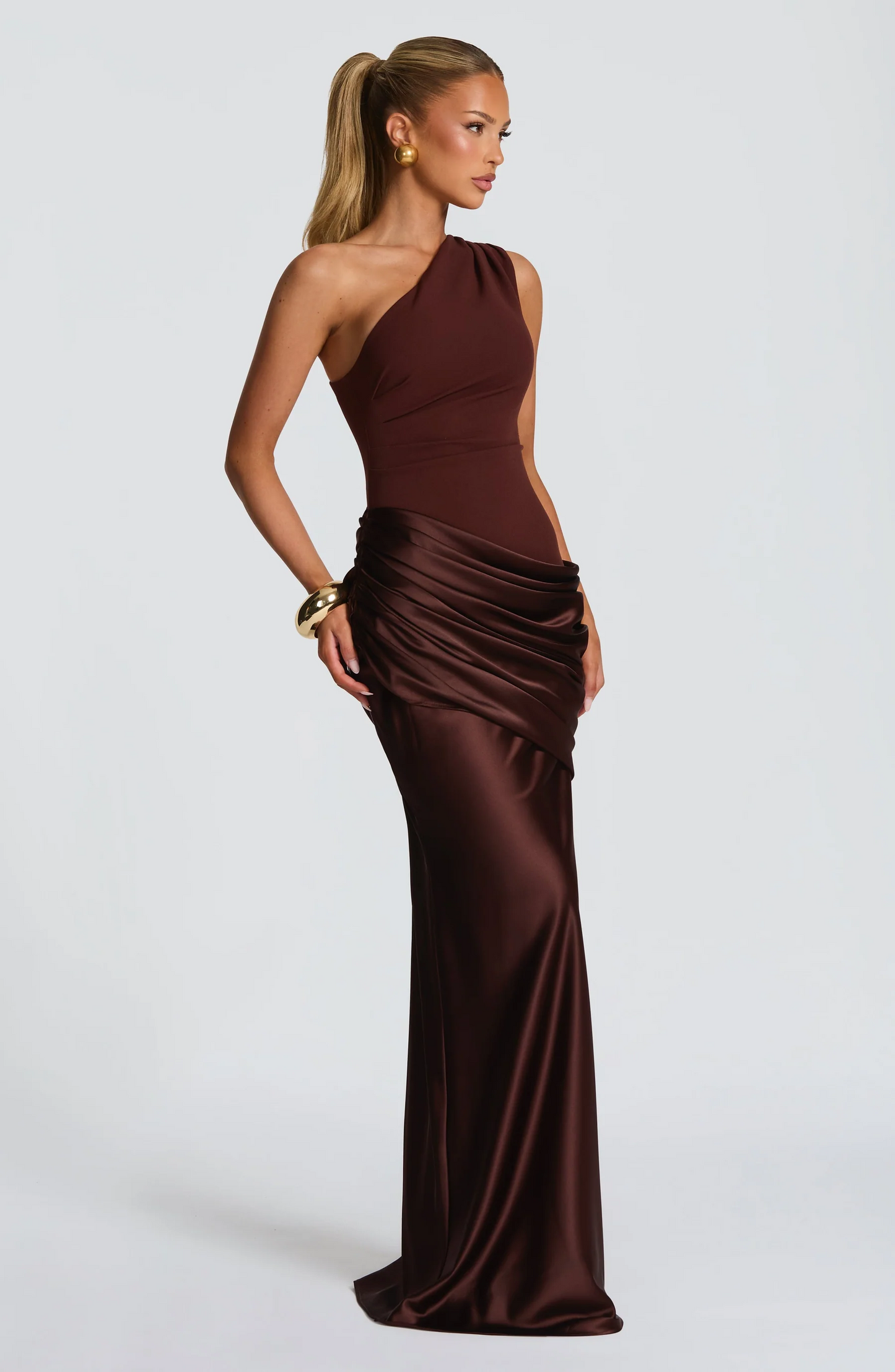 Burgundy formal one-shoulder maxi dress showing ruched hip detail and flowing skirt