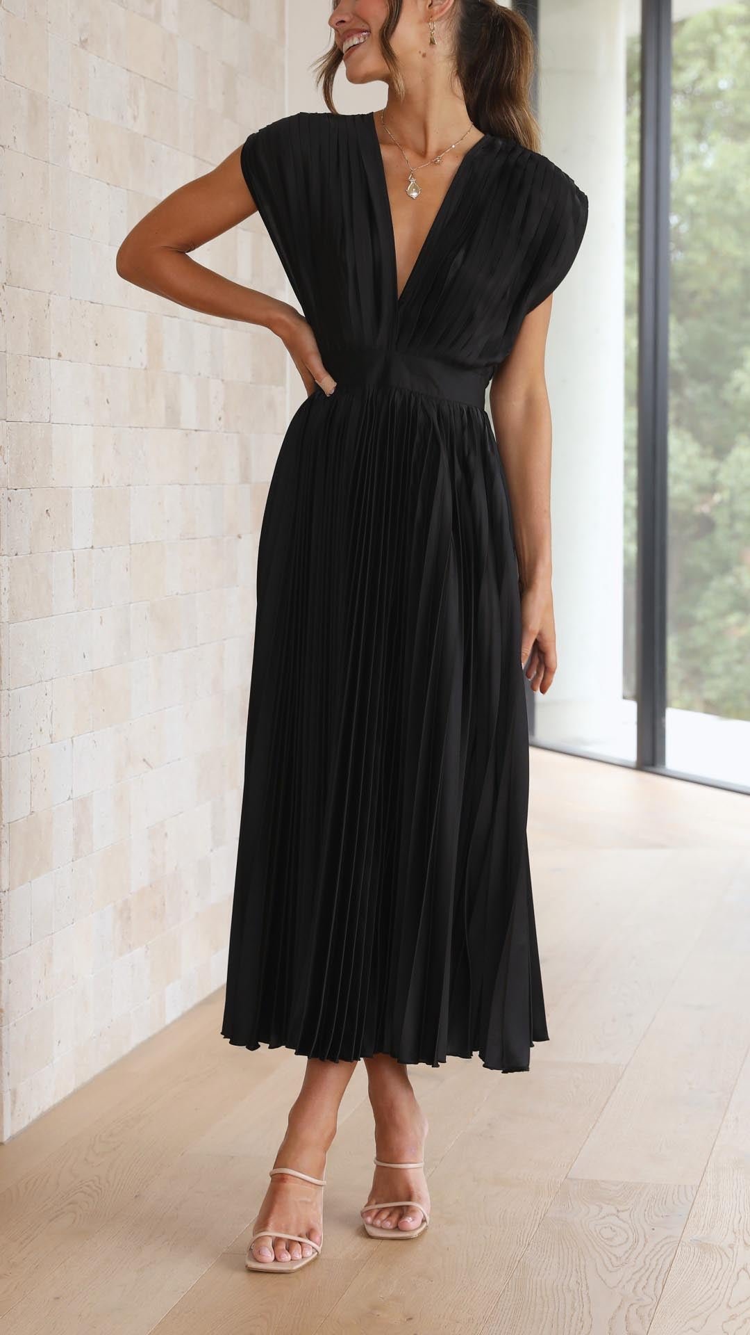 Black pleated midi dress front view with deep v-neckline and cinched waist