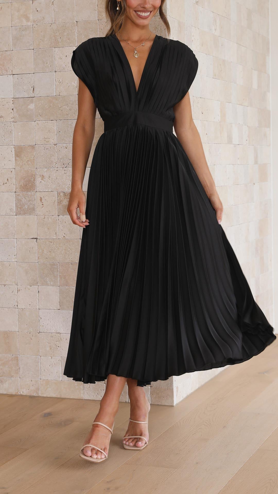 Back view of black pleated midi dress with tie closure detail
