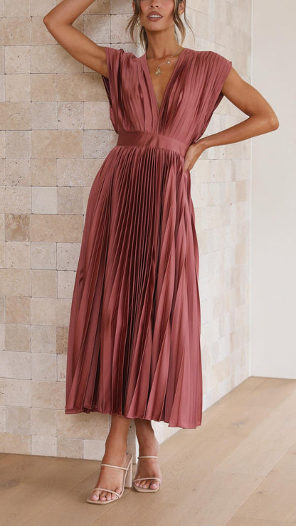Side view of mauve pleated midi dress showing v-neckline and flowing skirt