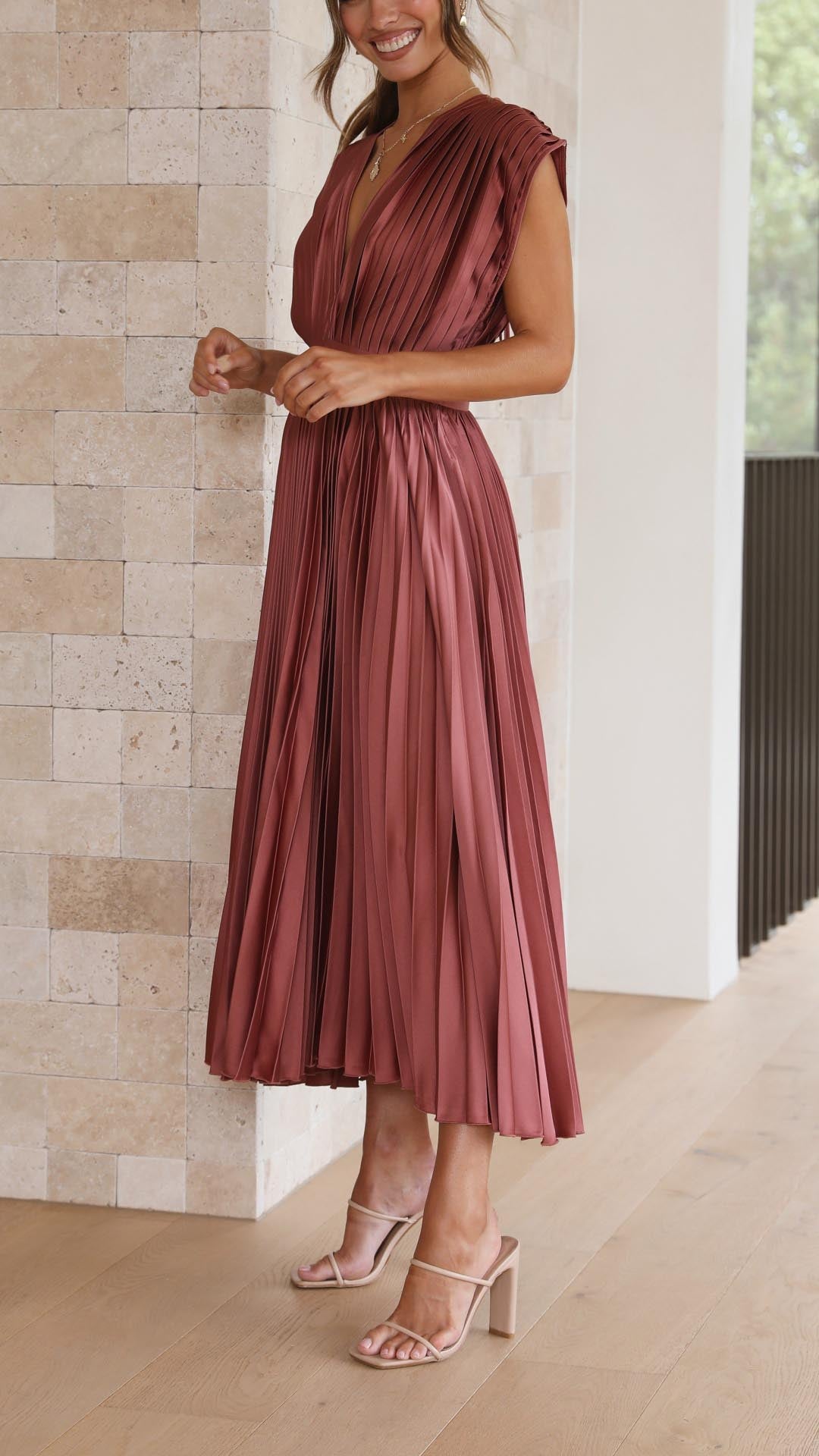 Three-quarter view mauve pleated midi dress showing v-neckline and high waist