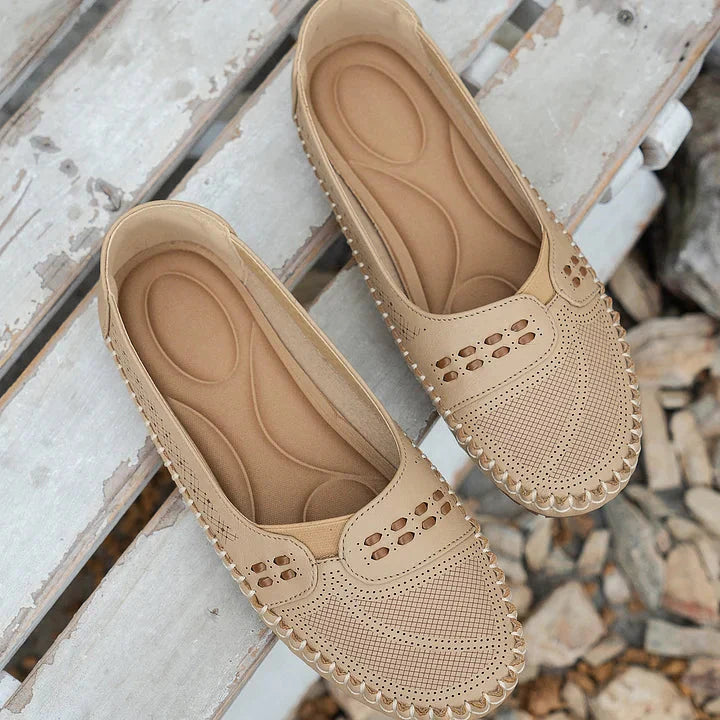 Cream loafer flat pair displaying contoured arch support insole and perforated leather
