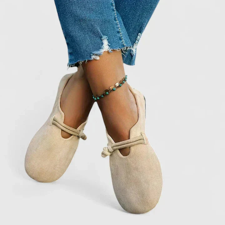 Beige suede orthopedic rope loafers worn on feet with ripped jeans