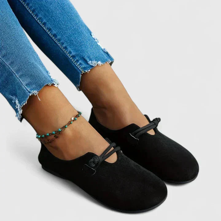 Black suede orthopedic loafer with rope detail worn on foot, side angle
