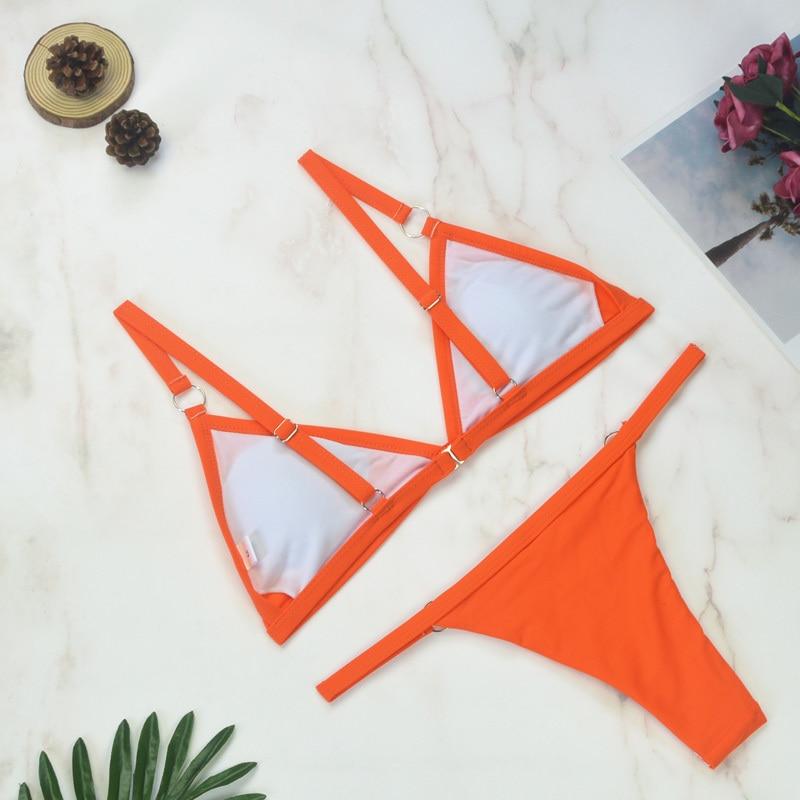 Orange triangle bikini showing metal ring accents and white lining
