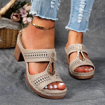 Beige perforated block heel sandal mule with decorative gold buckle and cutout design
