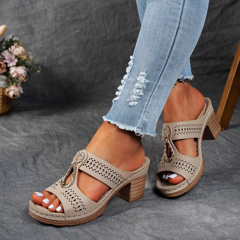 Beige perforated block heel sandal mule with cutout straps and gold chain embellishment