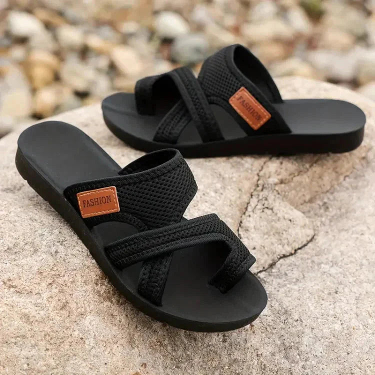 Flat lay of black textured cushioned sandals showing adjustable strap design