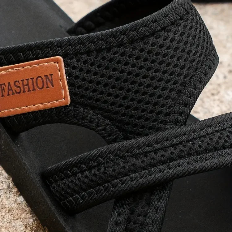 Close-up of black sandal strap showing textured fabric and cushioned padding detail