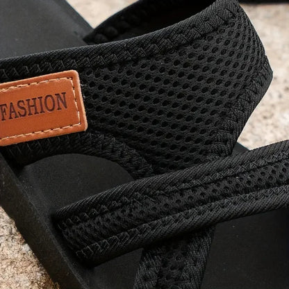 Close-up of black sandal strap showing textured fabric and cushioned padding detail