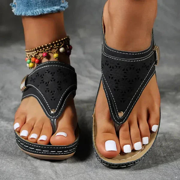 Front view of black perforated thong sandals showing orthopedic arch support and cushioned footbed