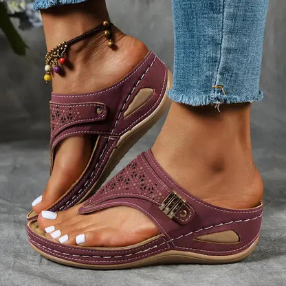 Burgundy perforated thong orthopedic sandal with metallic buckle and cushioned wedge heel